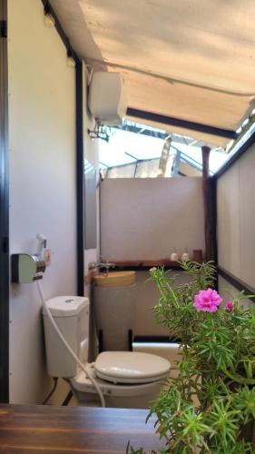 a bathroom with a toilet and a pink flower at Homestay in Nhơn Trạch