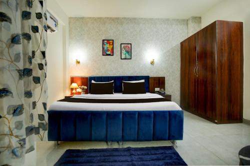 a bedroom with a blue bed and a wooden cabinet at Hotel O Riddhinn6 in Jalandhar