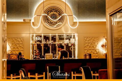 a man standing at a bar in a restaurant at Shams Albasra Hotel in Al Başrah