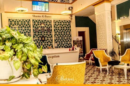a lobby with chairs and a table at Shams Albasra Hotel in Al Başrah