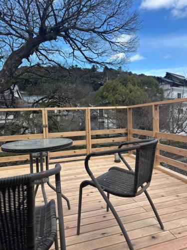 a table and two chairs on a deck with a table and a table at Onsen Yado Mizuguchi in Izu