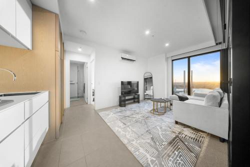 a kitchen and living room with a couch and a table at River View 1BR Docklands Apartment sleeps 3 in Melbourne