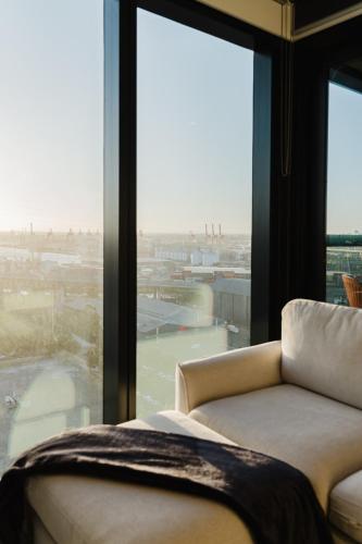 a living room with a couch and a large window at River View 1BR Docklands Apartment sleeps 3 in Melbourne