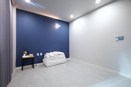 a room with a blue wall and a pile of towels at Incheon Freshia Hotel in Incheon