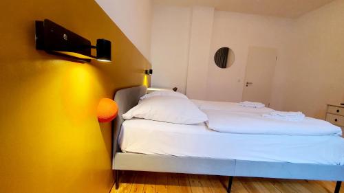 a small bed in a room with a yellow wall at Zimmer im Erdgeschoss II in Mannheim