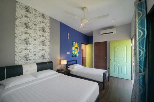 a bedroom with two beds and a green door at Papalu Villa in Kuala Penyu