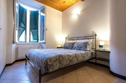 a bedroom with a bed with two lamps and a window at Macaia Village Life Room with AC #1 in Vernazza