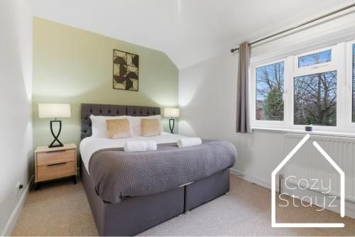 a bedroom with a bed and a window at Spacious 3 Bed with Pac-Man, Darts and 2 Parking spaces in Manchester