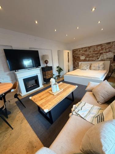 a large living room with a bed and a fireplace at Gästehaus am Privatsee in Biederitz