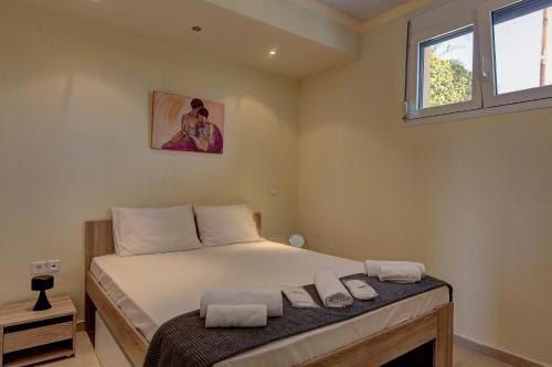 a bedroom with a bed with two towels on it at Hemera House Posidi H3 in Possidi