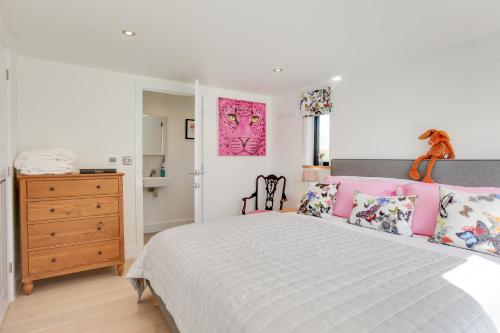 a bedroom with a large bed with pink pillows at Little Larks Barn in Felsted Station