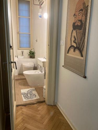 a bathroom with a sink toilet and a painting on the wall at 0.3 Stanze in Trieste
