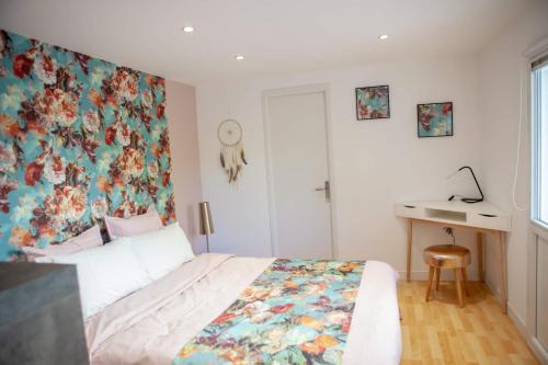 a bedroom with a floral wallpaper on the wall at La Petite Maison de Jane in Reims