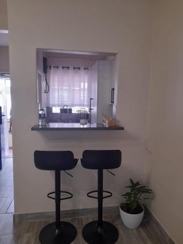 a kitchen with two bar stools and a mirror at Dawn's Place in Harare