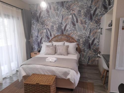 a bedroom with a bed with a floral wallpaper at Dawn's Place in Harare