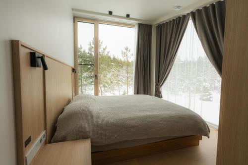 a bedroom with a bed and a large window at Dharma Resort in Rässa