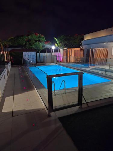 a swimming pool at night with a tennis court at MAR BIANCO - Gay Men Only in Maspalomas