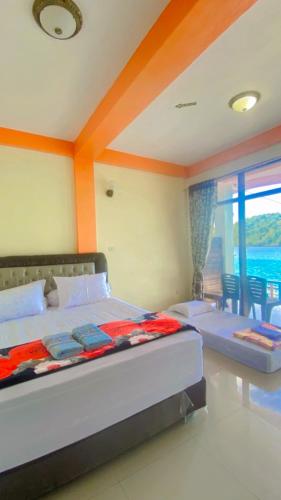 a bedroom with two beds and a large window at Yulia Resort in Sabang