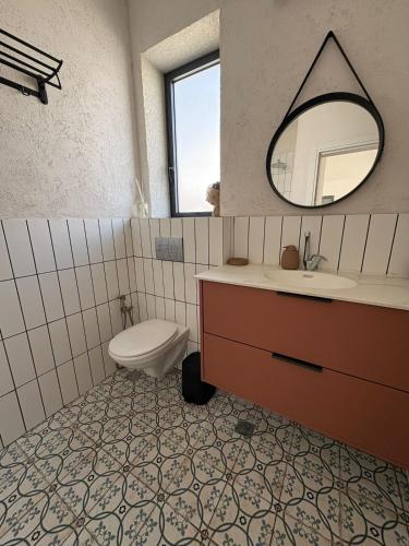 a bathroom with a sink and a toilet and a mirror at נופי דפנה in Dafna