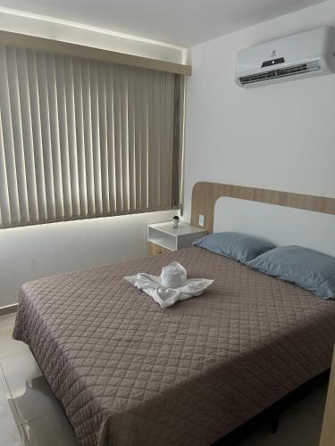 ein Zimmer mit einem Bett, auf dem ein Hut liegt in der Unterkunft Studio Design 310 in Sobral