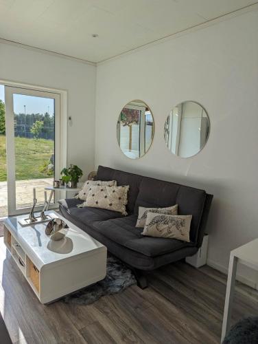 a living room with a couch and two mirrors at Tiny house accommodation in Frillesås! in Frillesås
