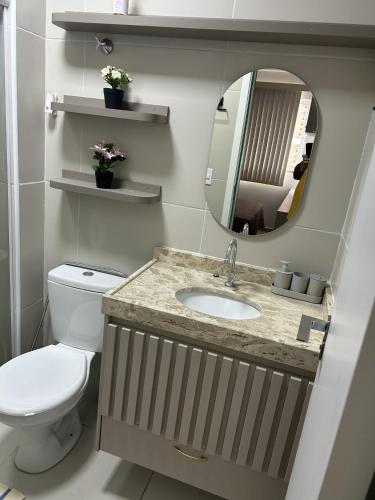 ein Badezimmer mit Toilette, Waschbecken und Spiegel in der Unterkunft Studio Design 310 in Sobral