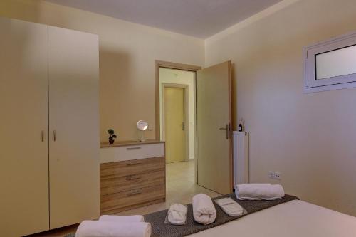 a bedroom with a bed and a dresser and a mirror at Hemera House Posidi H3 in Possidi