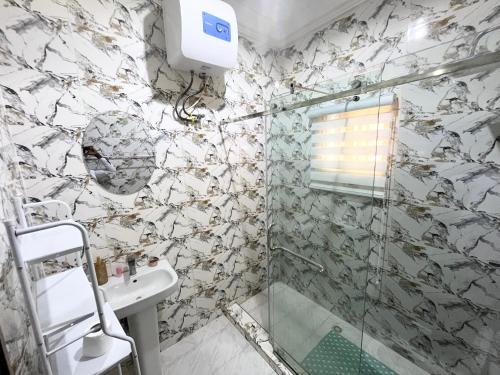 a bathroom with a shower and a sink at Deluxe Indulgence Hotel & Suites in Abuja
