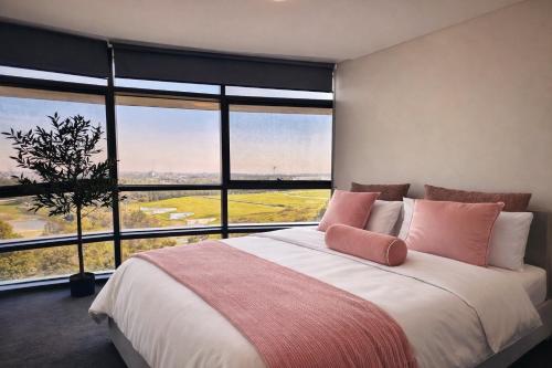 a bedroom with a large bed with a large window at Sleeps 6 Dreamy Designer Apt Wintergarden Dining 1min to Stadium & Free Parking in Sydney
