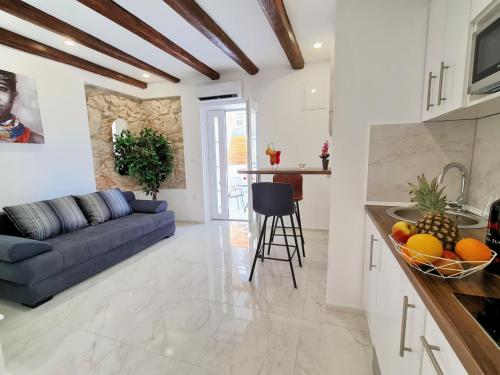 a kitchen and living room with a blue couch at AURA Apartments Novalja in Novalja