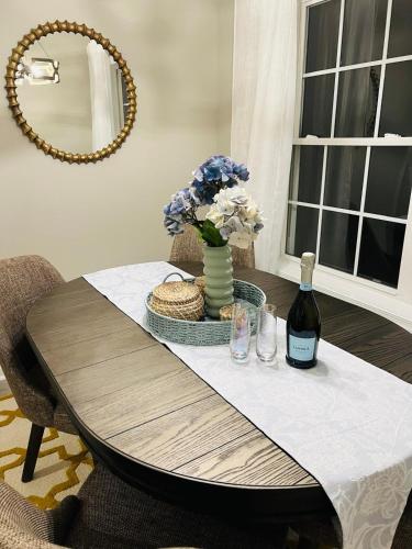 a table with a vase of flowers and a bottle of wine at Family perfect getaway 2 bedroom apartment in Rehoboth Beach