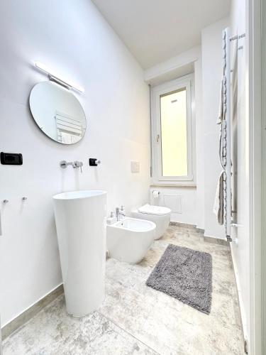 a white bathroom with a sink and a mirror at Cavour 16 Biella Studio Centro in Biella