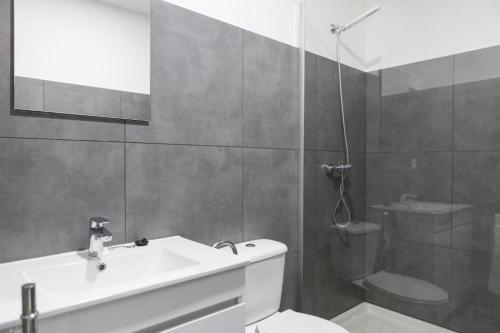 a bathroom with a toilet and a sink and a shower at Porto República Suites in Porto