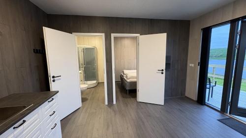 a room with two doors and a bedroom with a bed at Tommutún cottages in Borgarnes