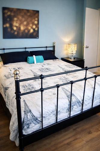 a bed with a black frame and a white comforter at Robertson Homes of Love in Los Angeles
