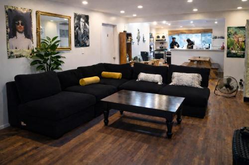 a living room with a black couch and a coffee table at Robertson Homes of Love in Los Angeles