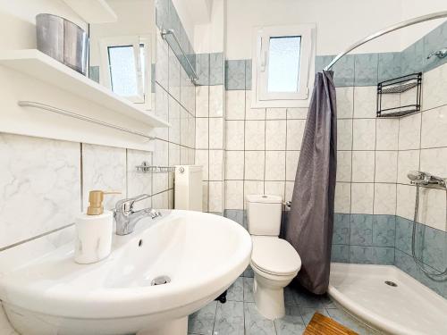 a white bathroom with a sink and a toilet at Dimeli 1 in Plaka Litochorou
