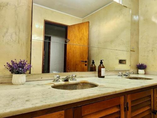 a bathroom with two sinks and a large mirror at Estancia Bogotá in Ciudad Lujan de Cuyo