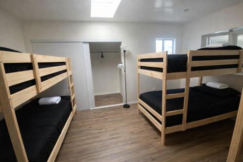 a room with three bunk beds and a hallway at Robertson Homes of Love in Los Angeles