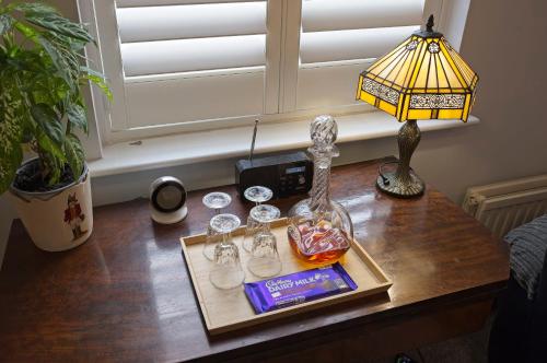 a table with glasses and a lamp on it at Ground floor well appointed cosy flat in Ludlow in Ludlow