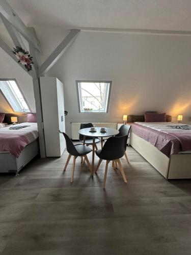 a room with two beds and a table and chairs at Oppiner Straße 14 Trotha4 in Halle an der Saale
