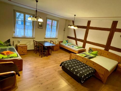 a room with three beds and a table in it at Ferienwohnung "Ankerplatz" mit 2 Schlafzimmern in Rheinsberg