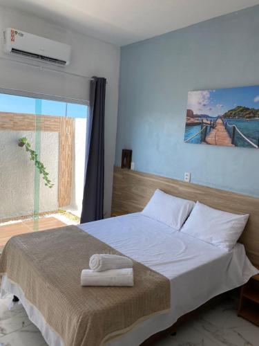 a bedroom with a large bed with a window at Recanto das Oliveiras in Corumbau