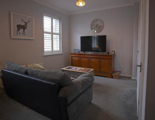 a living room with a couch and a tv at Ground floor well appointed cosy flat in Ludlow in Ludlow