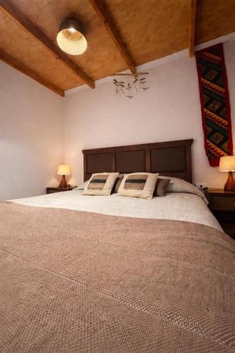 una camera da letto con un letto grande con due lampade di Chill Atacama a San Pedro de Atacama