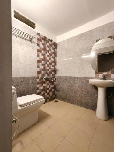 a bathroom with a toilet and a sink at Hidden Roots Sakleshpur in Hanbalu