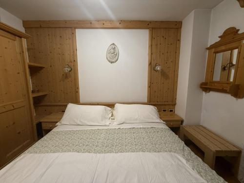 a bed in a room with wooden walls at Campiglio Trilocale Dolomiti in Madonna di Campiglio
