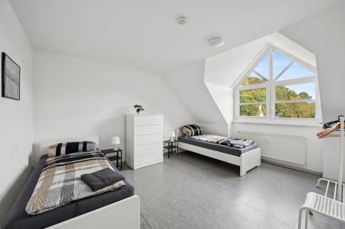 a white bedroom with a bed and a window at Worker Place Lennestadt in Lennestadt
