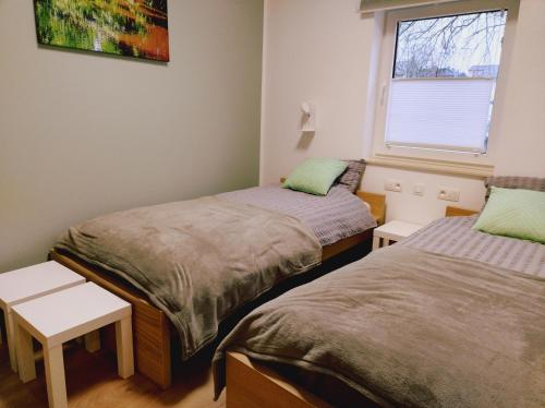 two twin beds in a room with a window at Riverside Holiday in Eupen