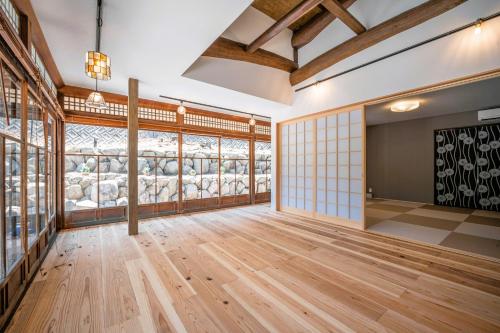 a large room with wooden floors and a wall of windows at AWAJI PRIVATE Villa 神蔵-KAGURA in Awaji